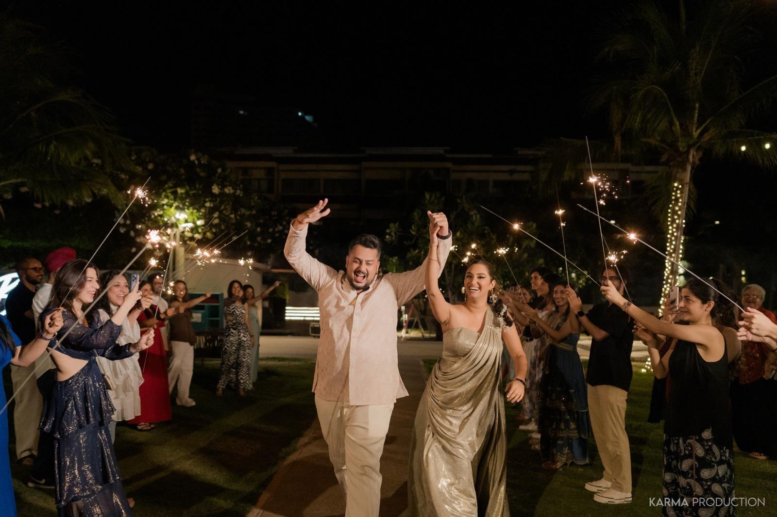 A newlywed couple celebrating beneath sparklers